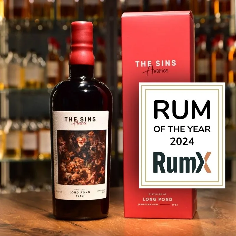 La bouteille Distilia The Sins Avarice à côté de son coffret rouge et d'une plaque RumX Rhum de l'année 2024.