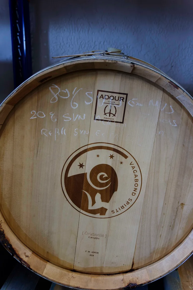 Fassboden mit eingebranntem Vagabond Spirits Logo und Stempel der Küferei Adour, darüber Kreidenotizen.