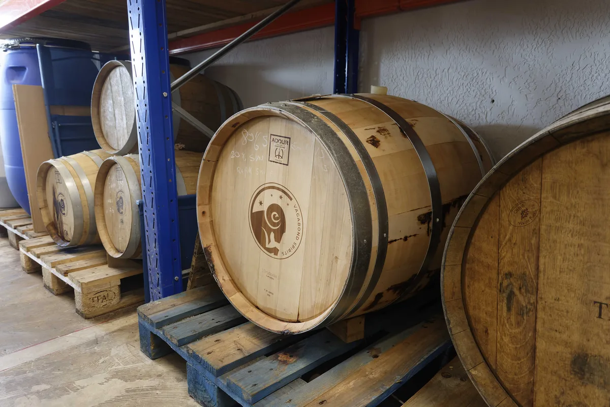 Fässer auf Paletten im Keller von Vagabond Spirits, eines mit dem Hauslogo eingebrannt.