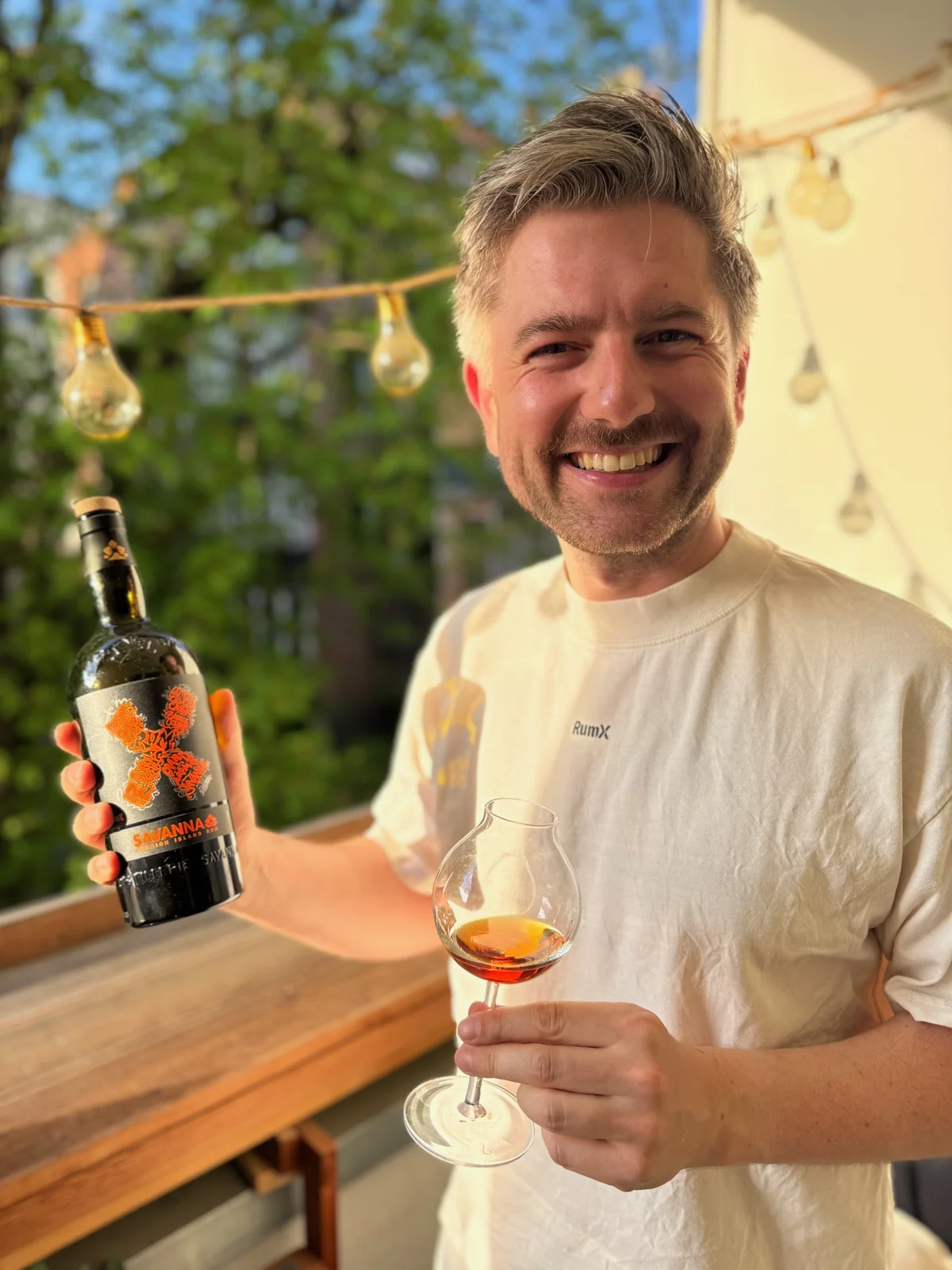 Oliver Gerhardt, RumX founder, with a bottle of Savanna rum and a Glencairn glass