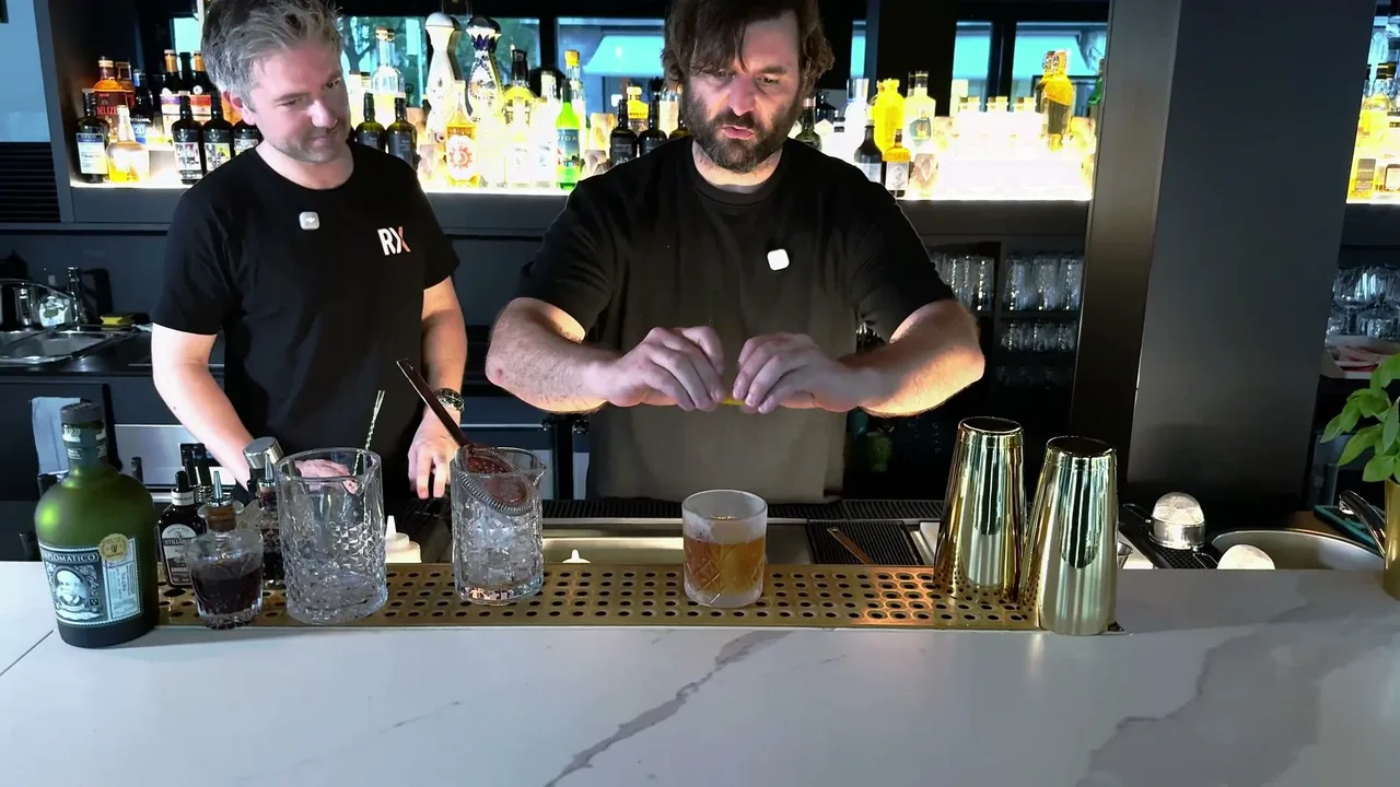 Stefan Glück drückt die Orangenzeste über dem fertigen Diplomático Old Fashioned aus, links im Bild die Diplomático-Flasche
